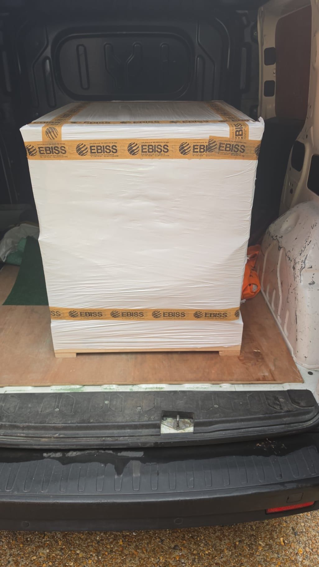 A white wrapped pallet of boxes inside a van